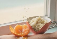 Exfoliation Methods You Need to Try for a Fresh, Radiant Complexion Half-peeled tangerine dripping onto an arm with a sea-salt scrub.