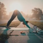 Yoga for Beginners: A Step-by-Step Guide to Starting Your Practice Woman doing yoga on a sidewalk, with a bagel and phone nearby.