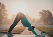 Yoga for Beginners: A Step-by-Step Guide to Starting Your Practice Woman doing yoga on a sidewalk, with a bagel and phone nearby.